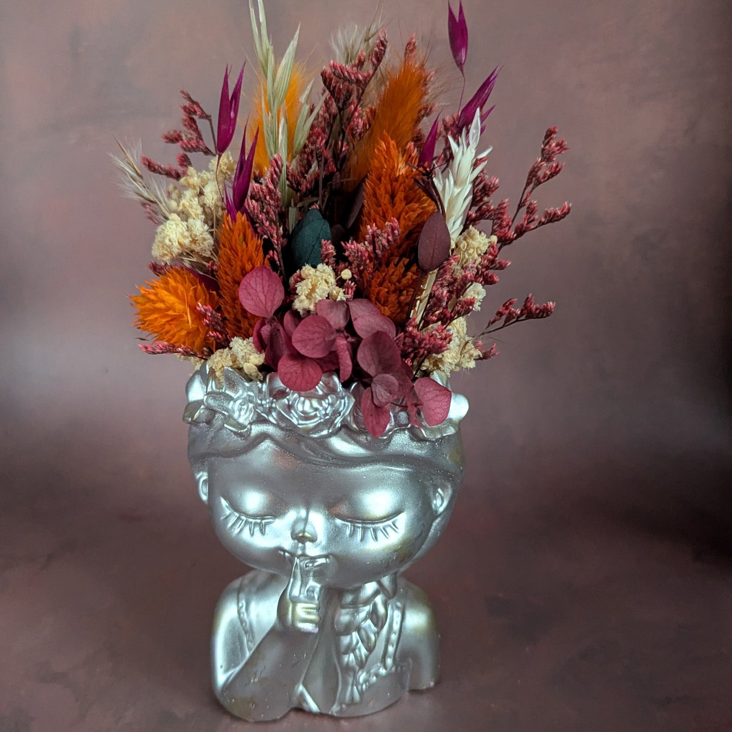 gardienne en résine minérale teintée en argenté. Habillé d'une coiffe en fleurs séchées de couleurs parme
