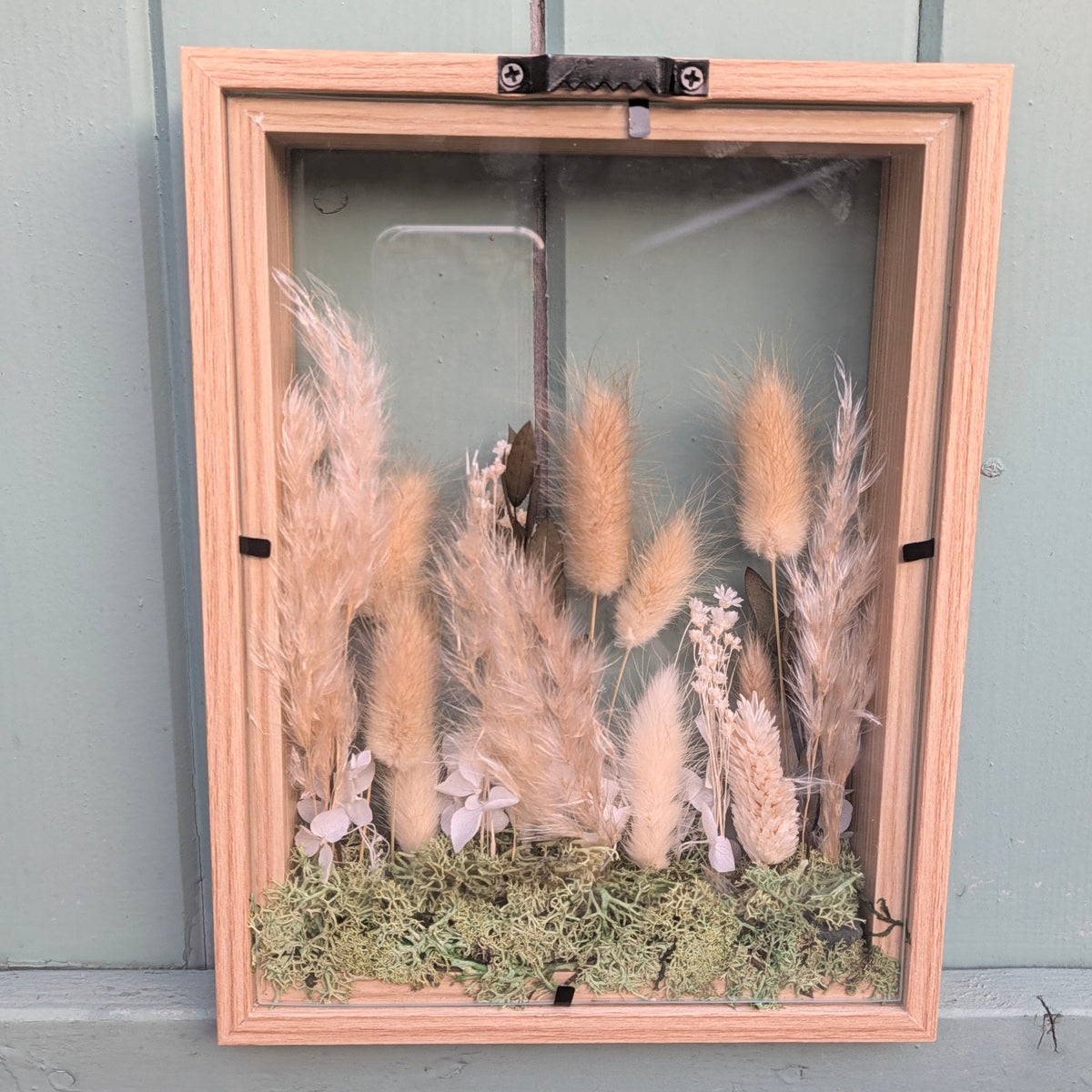 Vue arrière du cadre La Clairière de la collection Soria, montrant le cadre en bois, les deux plaques de verre et son système d’accroche mural.