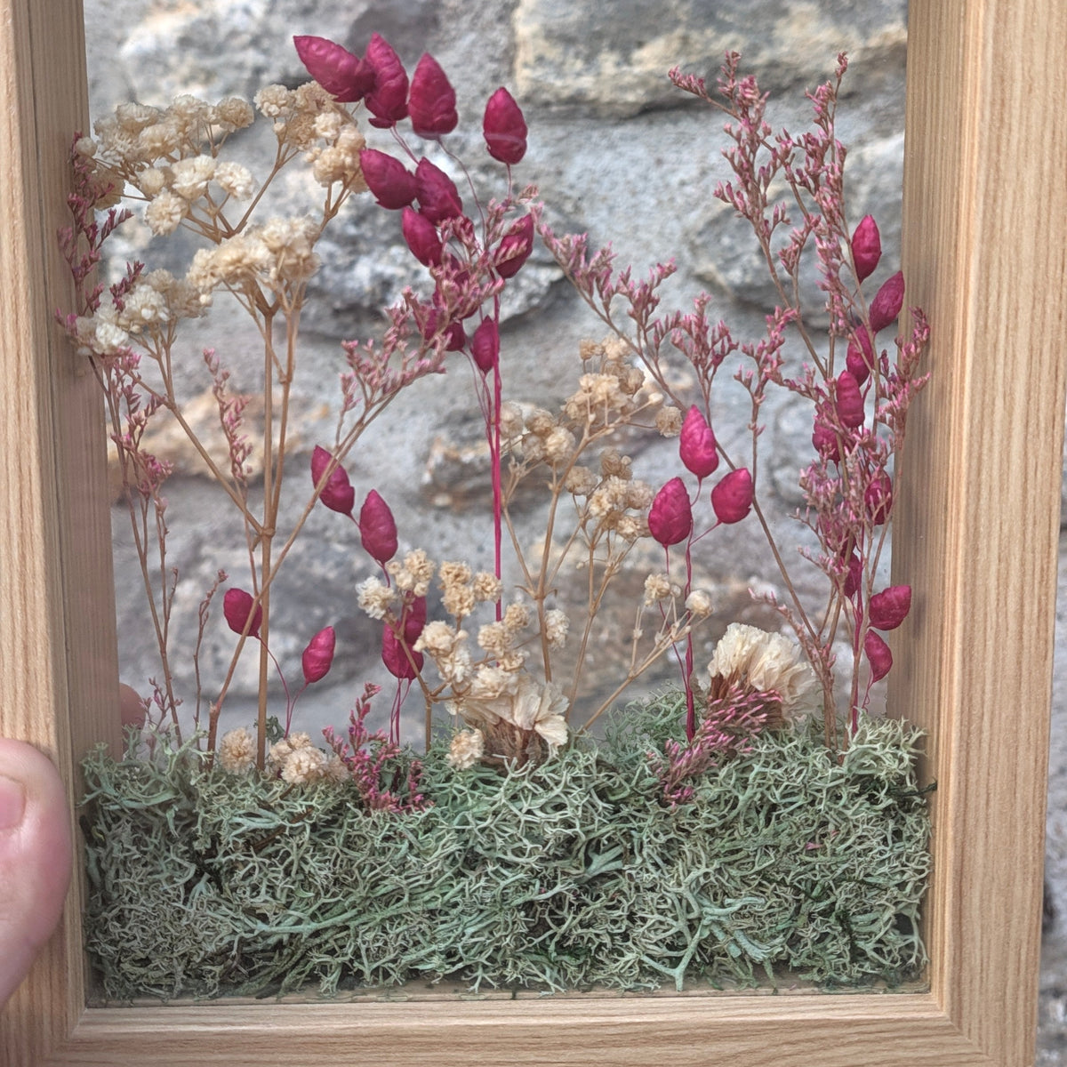 Détail de la composition florale Le Jardin des brumes, réalisée à la main avec des fleurs séchées et de la mousse végétale.