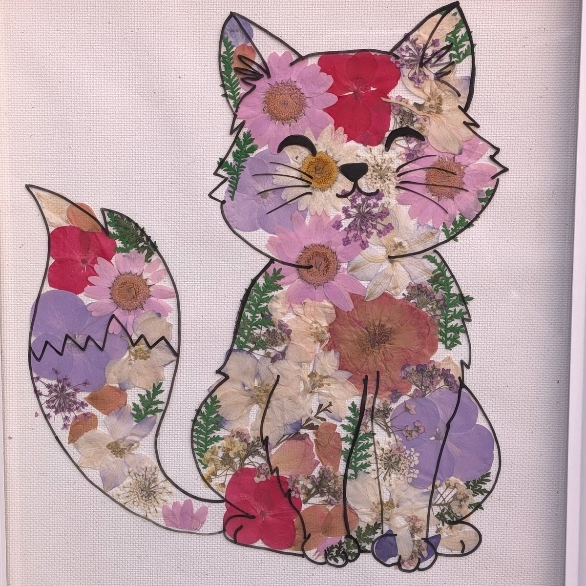 Détail du cadre Néo de la collection Faunéa, montrant les véritables fleurs séchées et pressées qui composent le chat fleuri.