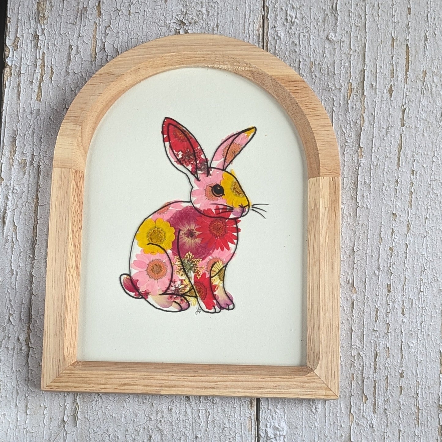 Cadre Faunéa en forme d’arche avec dessin imprimé d’un lapin entouré de fleurs séchées pressées roses et jaunes