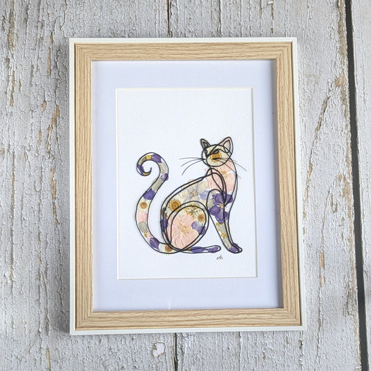 Cadre Faunéa avec dessin imprimé d’un chat entouré de fleurs séchées pressées aux tons violets et rosés