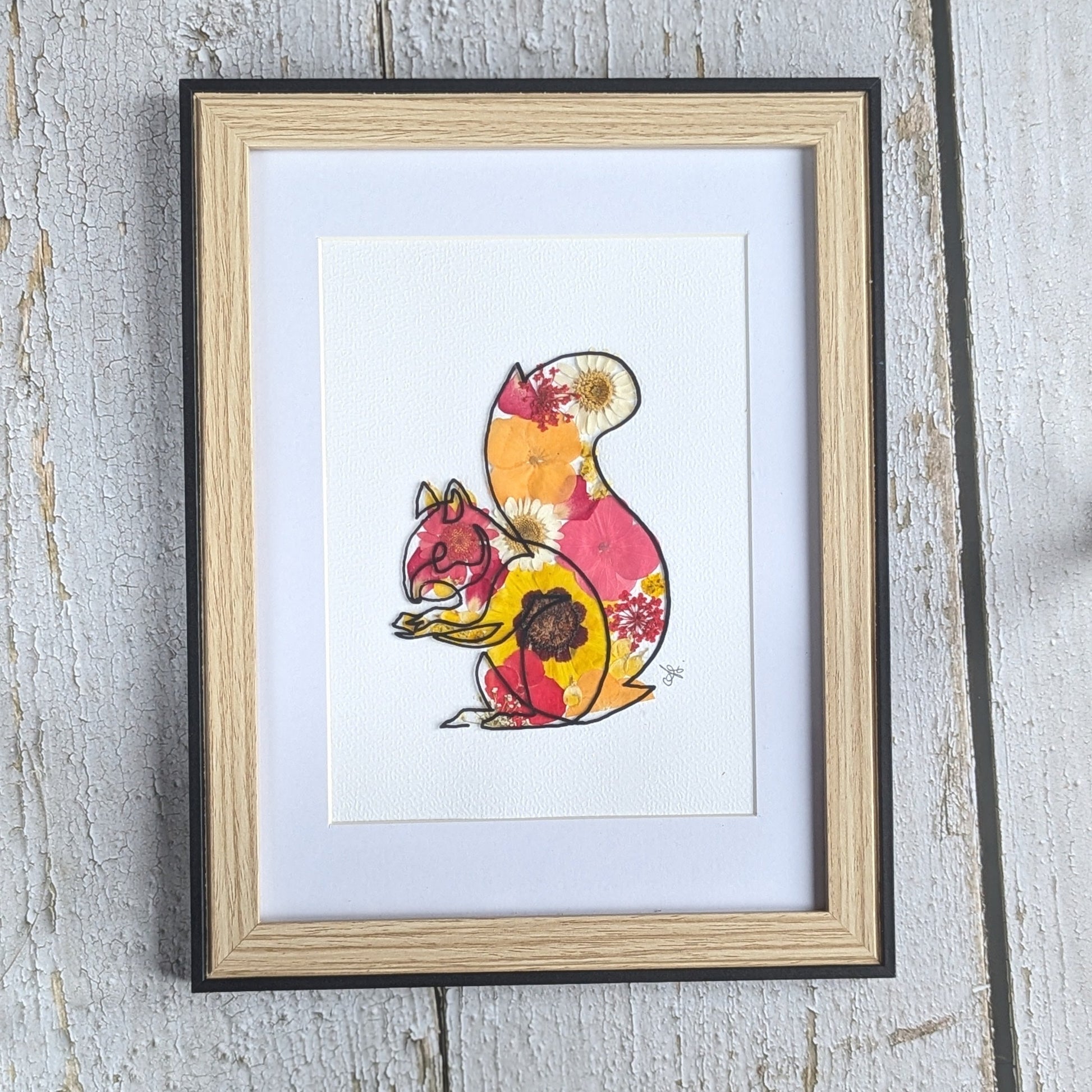 Cadre Faunéa avec dessin sur vitre d’un écureuil et fleurs séchées pressées aux tons jaunes, orangés et rosés