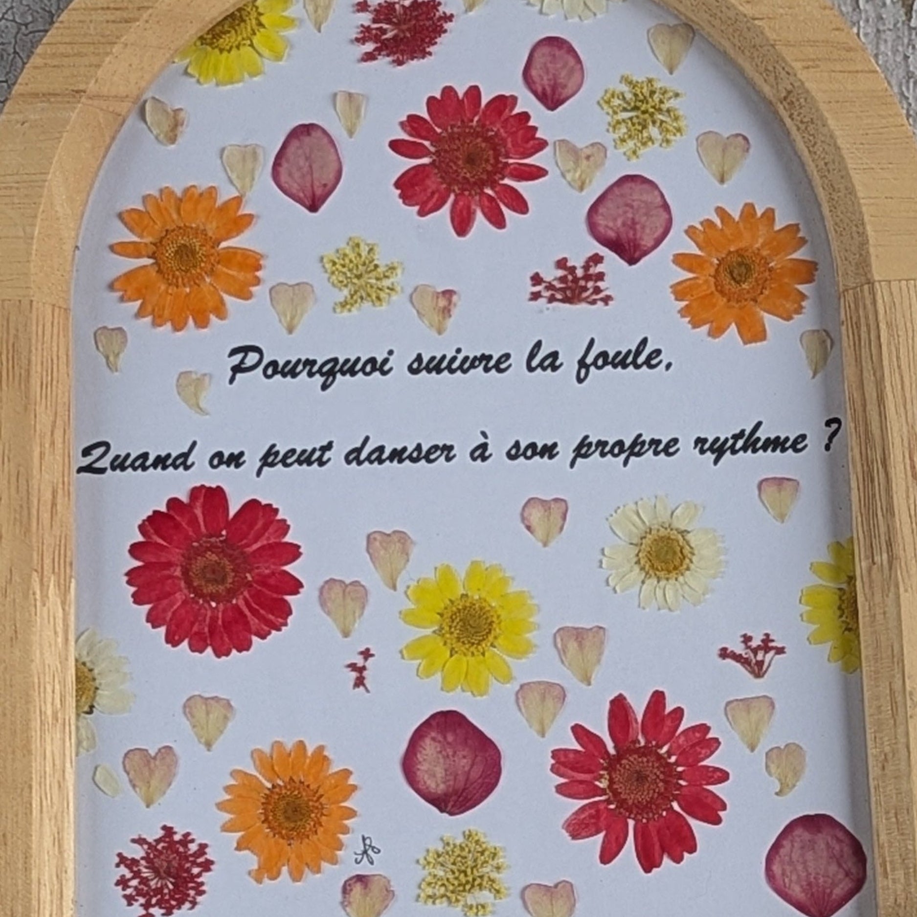 Détail des fleurs séchées colorées autour du message du cadre Florésie