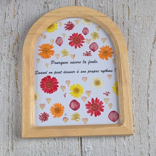 Cadre Florésie en forme d’arche avec message « Pourquoi suivre la foule, quand on peut danser à son propre rythme ? » et fleurs séchées colorées