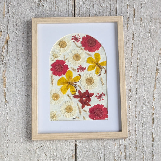Cadre Florésie en forme d’arche avec composition de fleurs séchées pressées rouges, jaunes et blanches