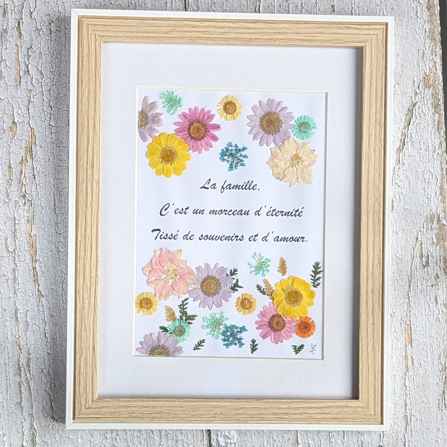 Cadre Florésie avec texte inspirant sur la famille et composition de fleurs séchées pressées colorées