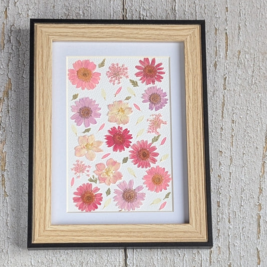 Cadre Herbier coloré avec composition de fleurs séchées pressées roses et pastel sur fond clair