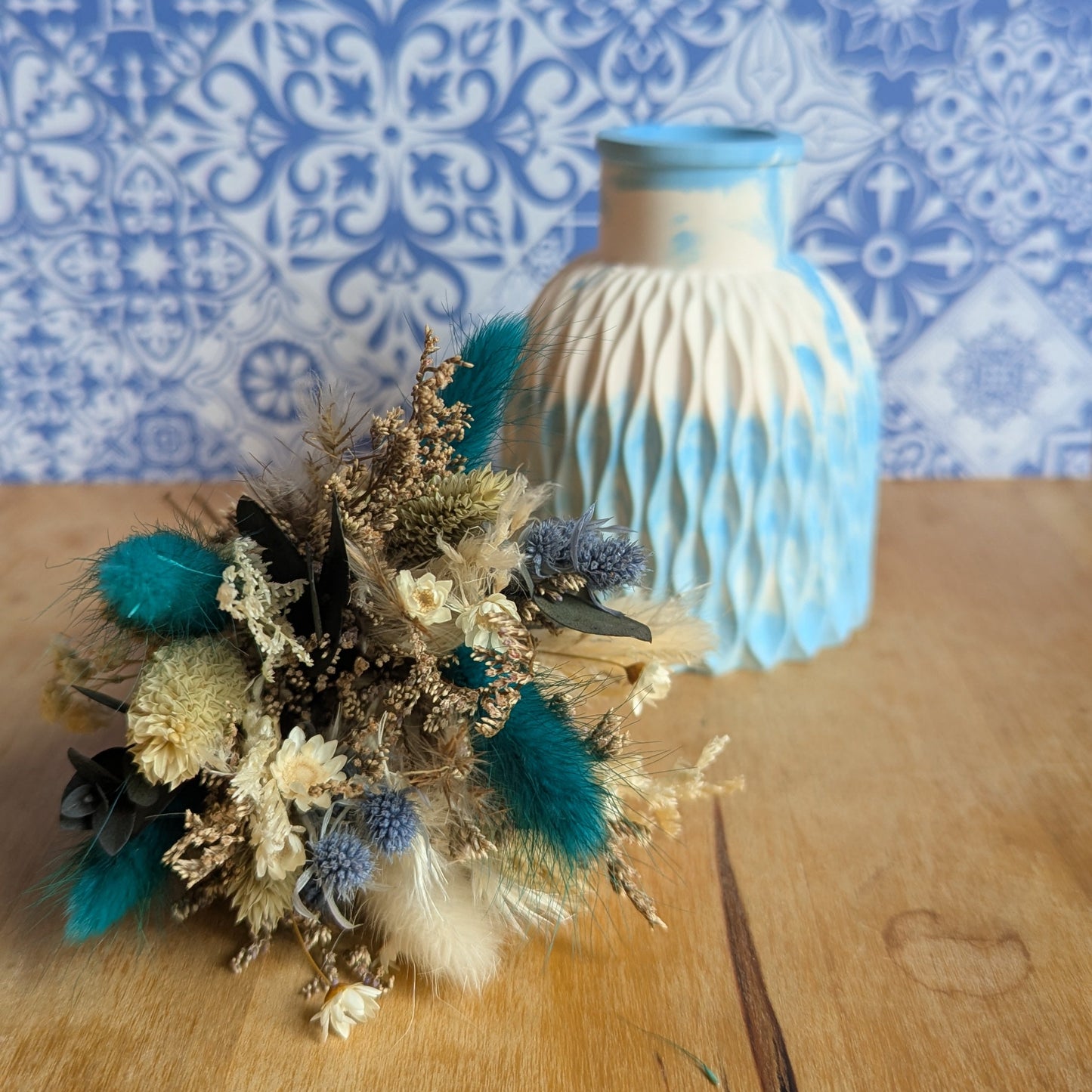 Bouquet de fleurs séchées et vase en résine minérale posés côte à côte, tons bleutés, collection Sorane
