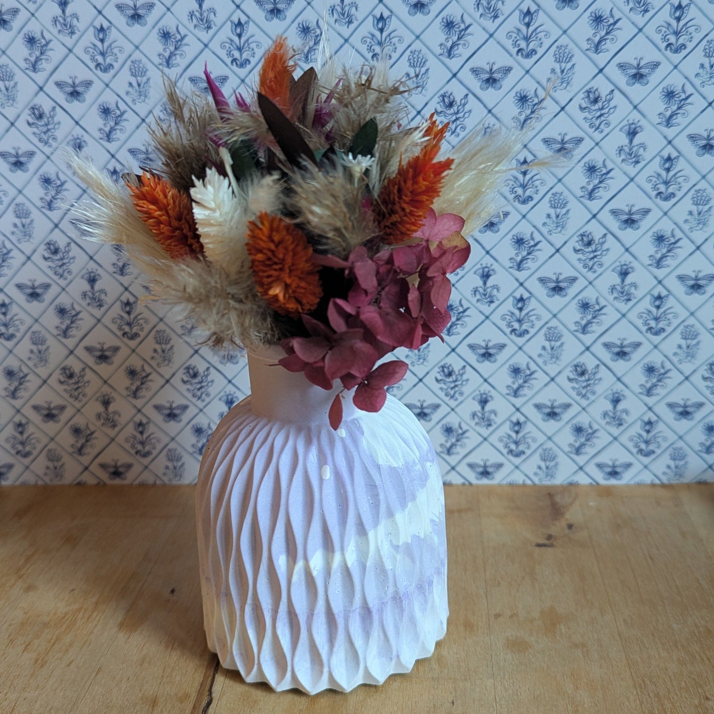 bouquet de la collection Sorane en fleurs séchées blanches, orange et parme dans un vase en résine minérale